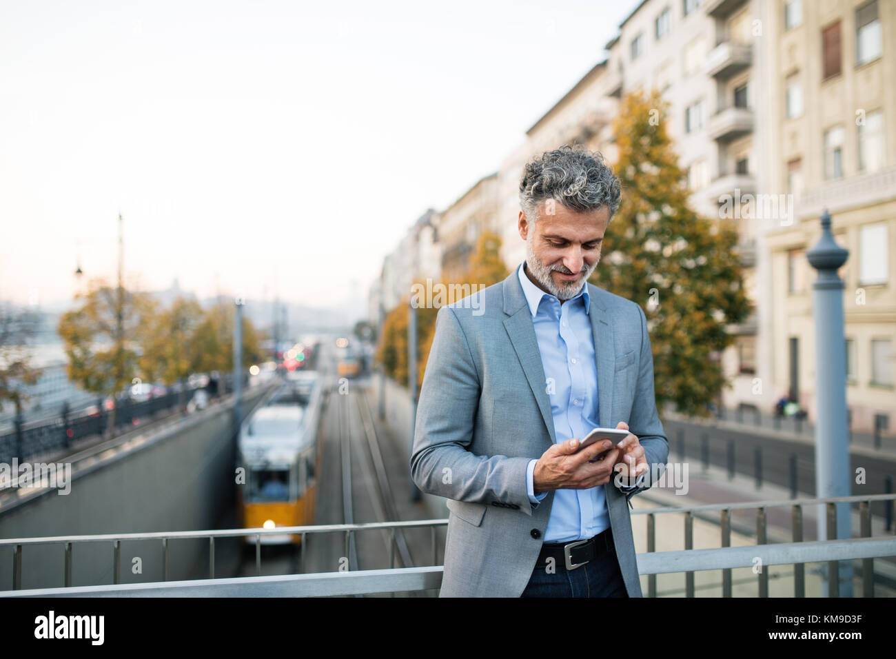 Mature businessman with a smartphone in a city Stock Photo - Alamy