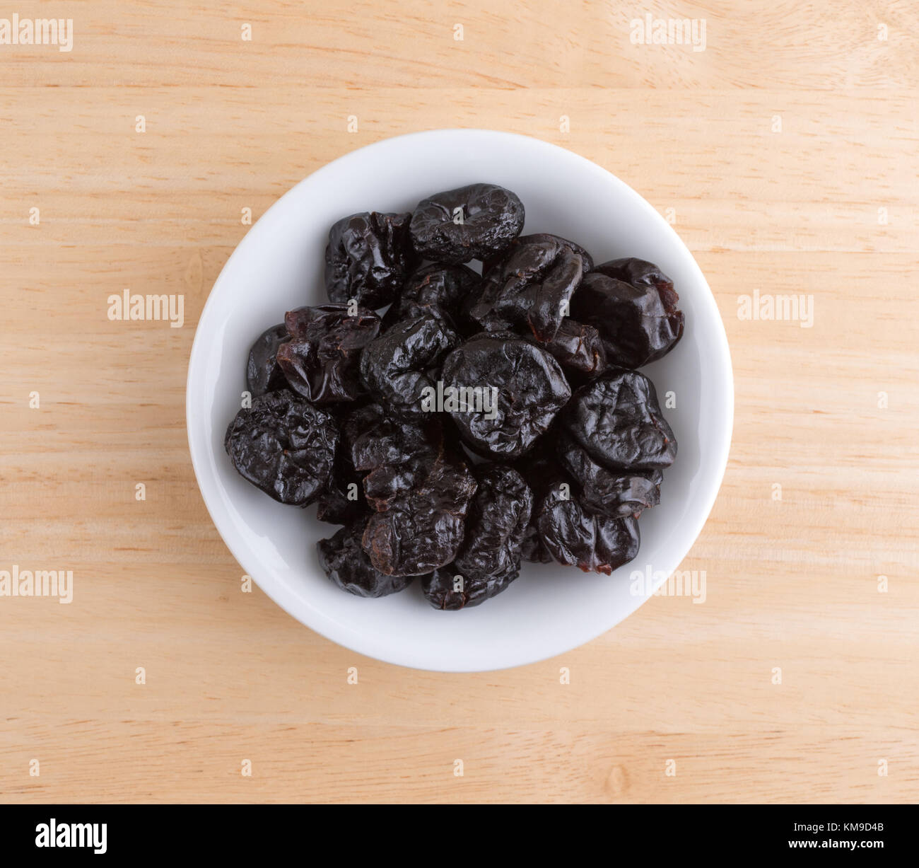Top view of a portion of dried bing cherries in a small white bowl atop