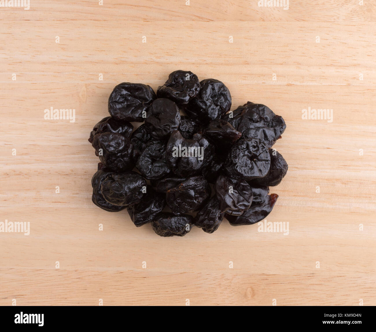 Top view of a portion of dried bing cherries on a wood cutting board