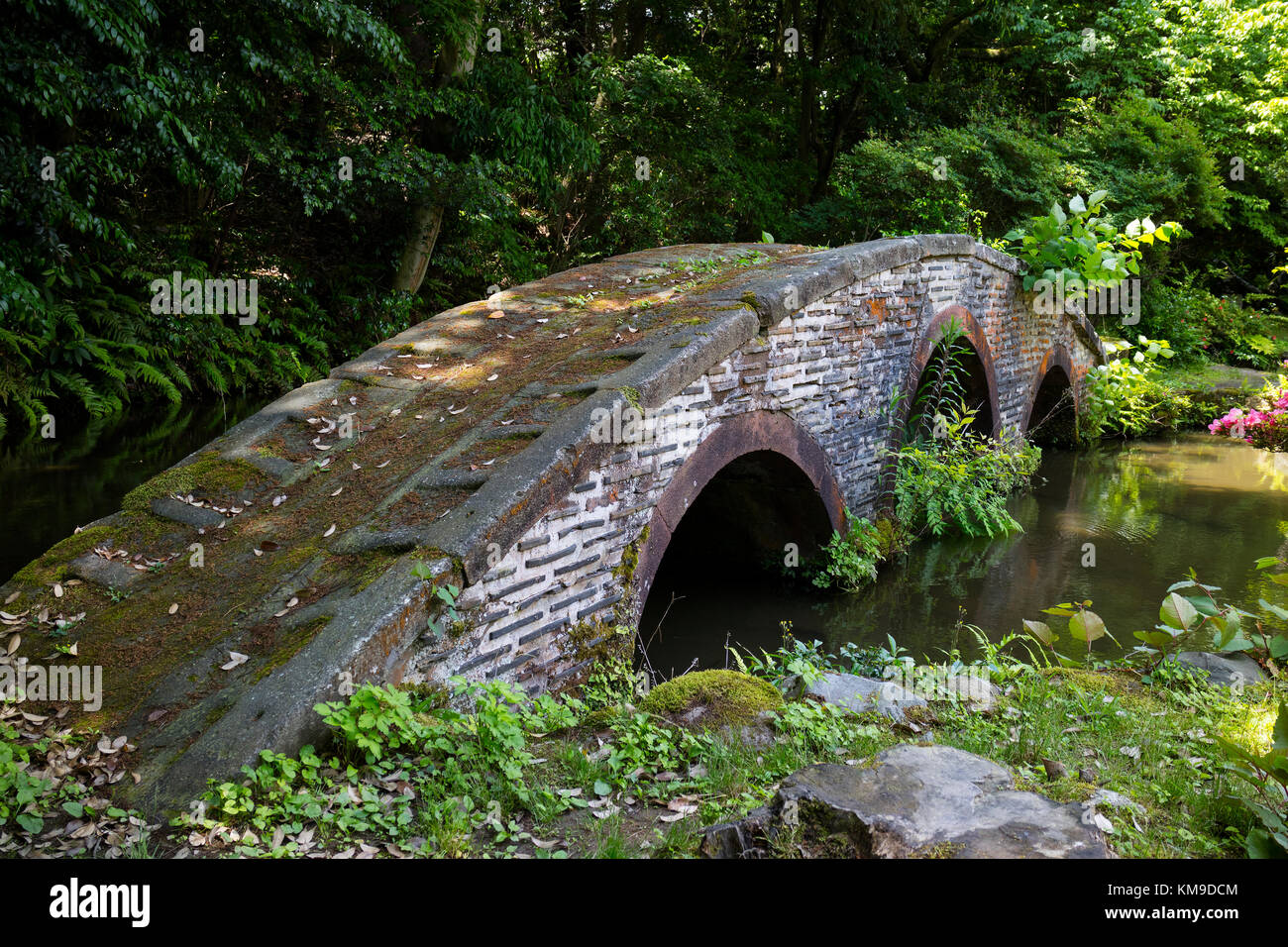 Kanazawa - Japan, June 9, 2017: Historical stone bridge in the garden of the Oyama ninja Shrine in springtime Stock Photo