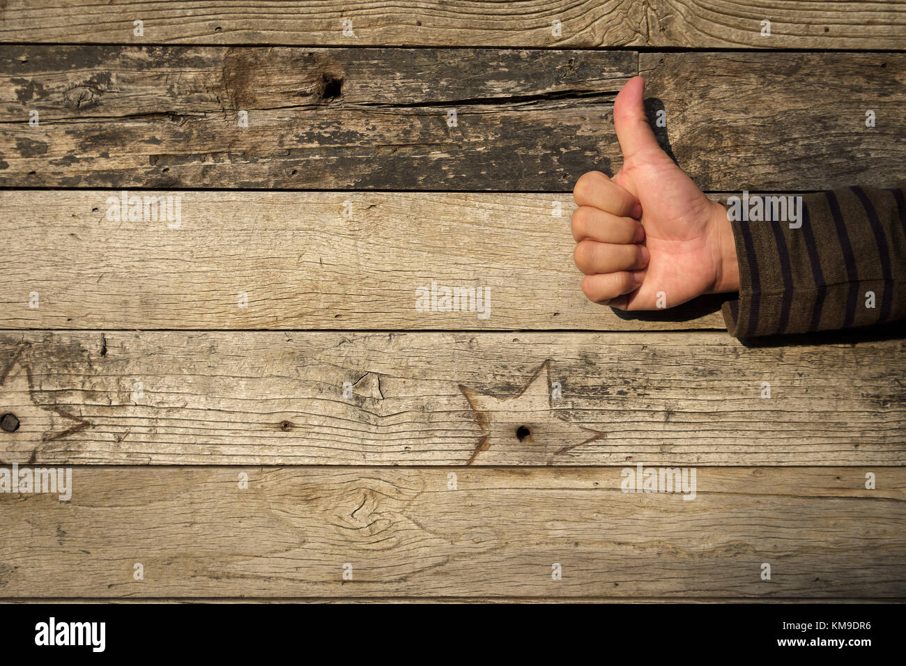 Thumbs up on a Rustic weathered barn wood background Stock Photo