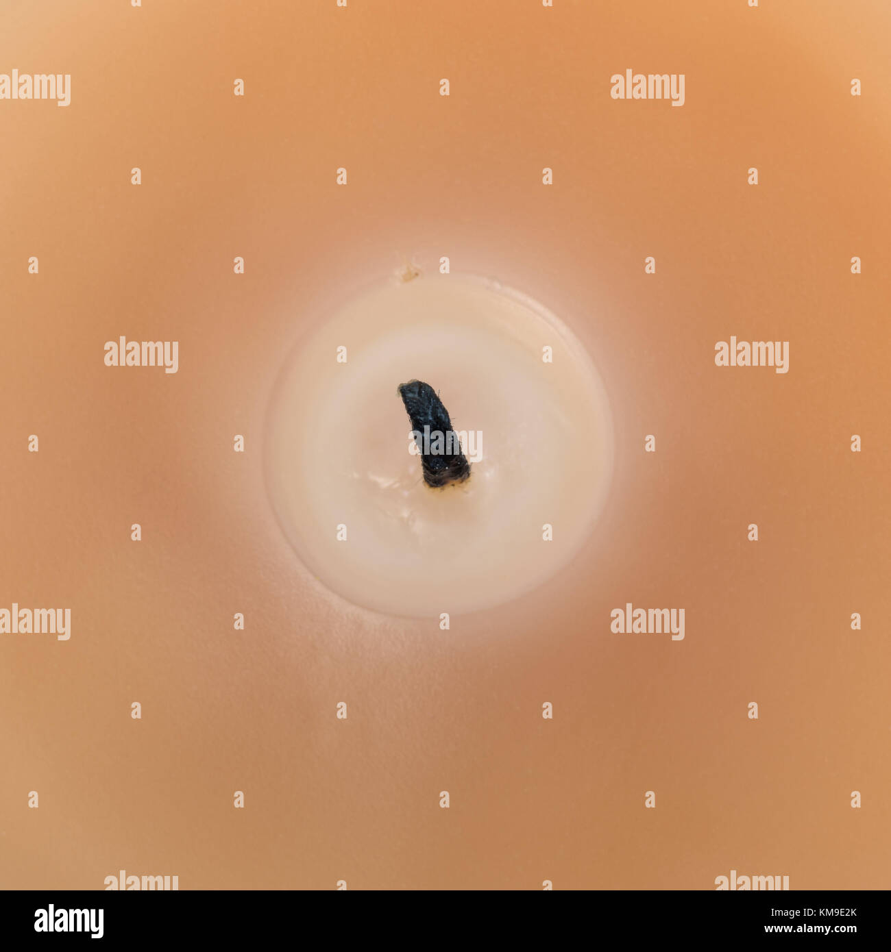 Very close view of a scented candle showing a blackened burnt wick