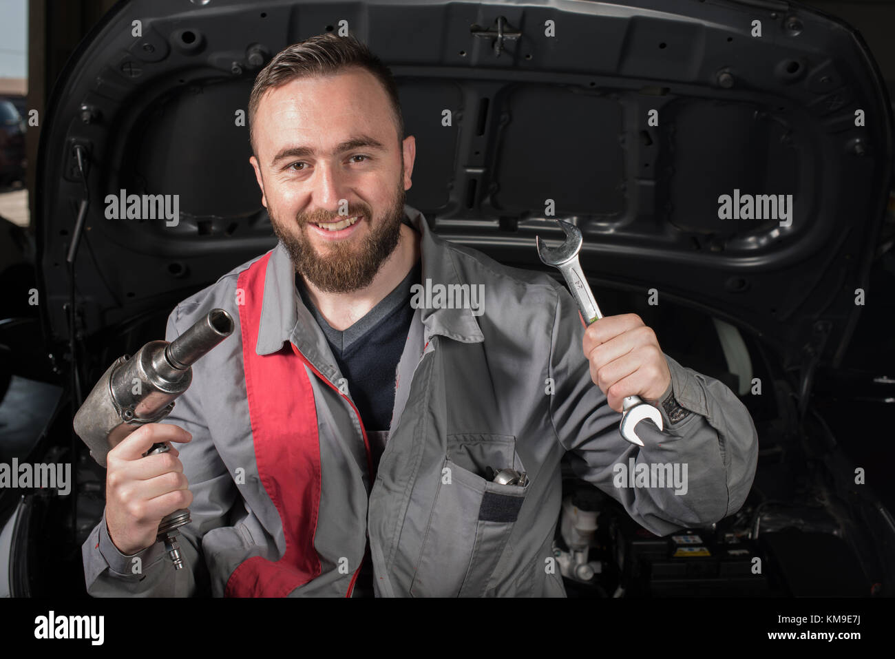 Mechanic holding an electric wrench and spanner Stock Photo