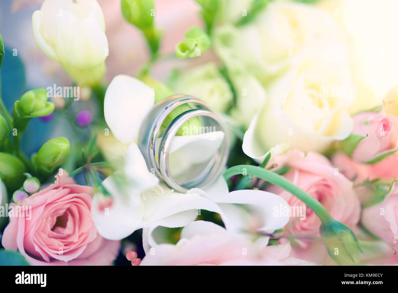 Wedding rings and bouquet of flowers Stock Photo