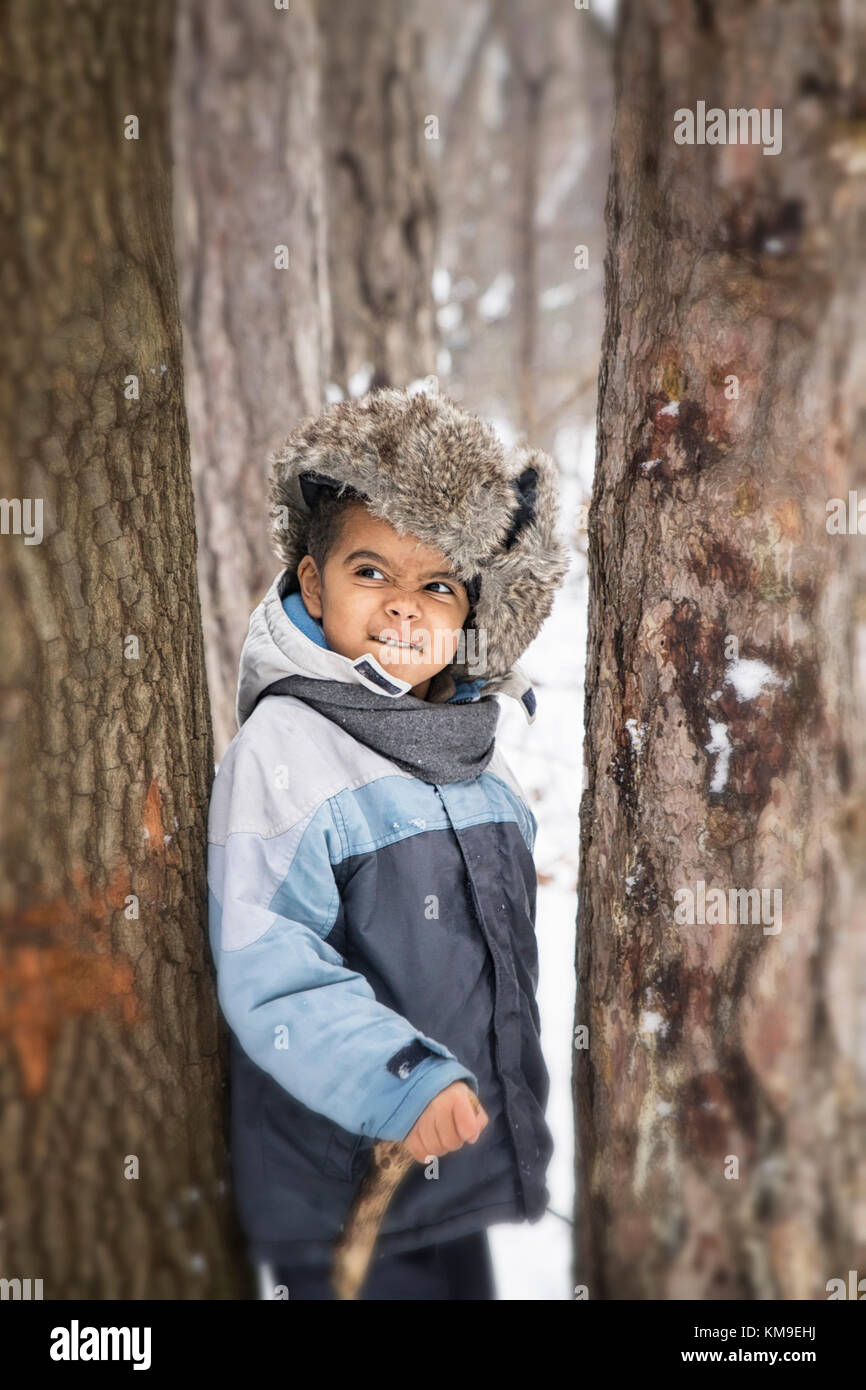 Boy standing in the forest in winter Stock Photo