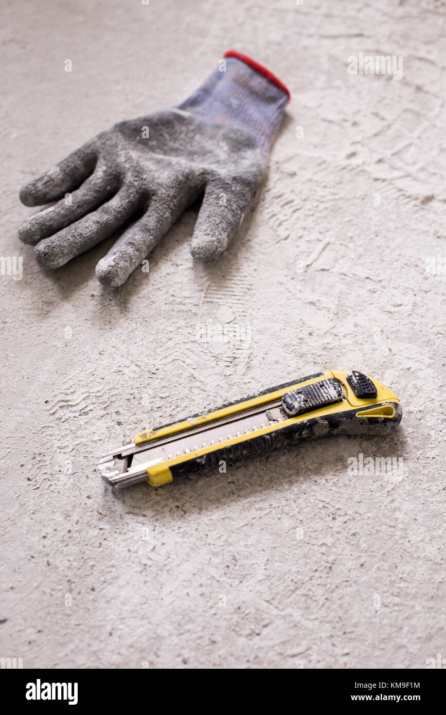 Glove and utility knife on the ground Stock Photo