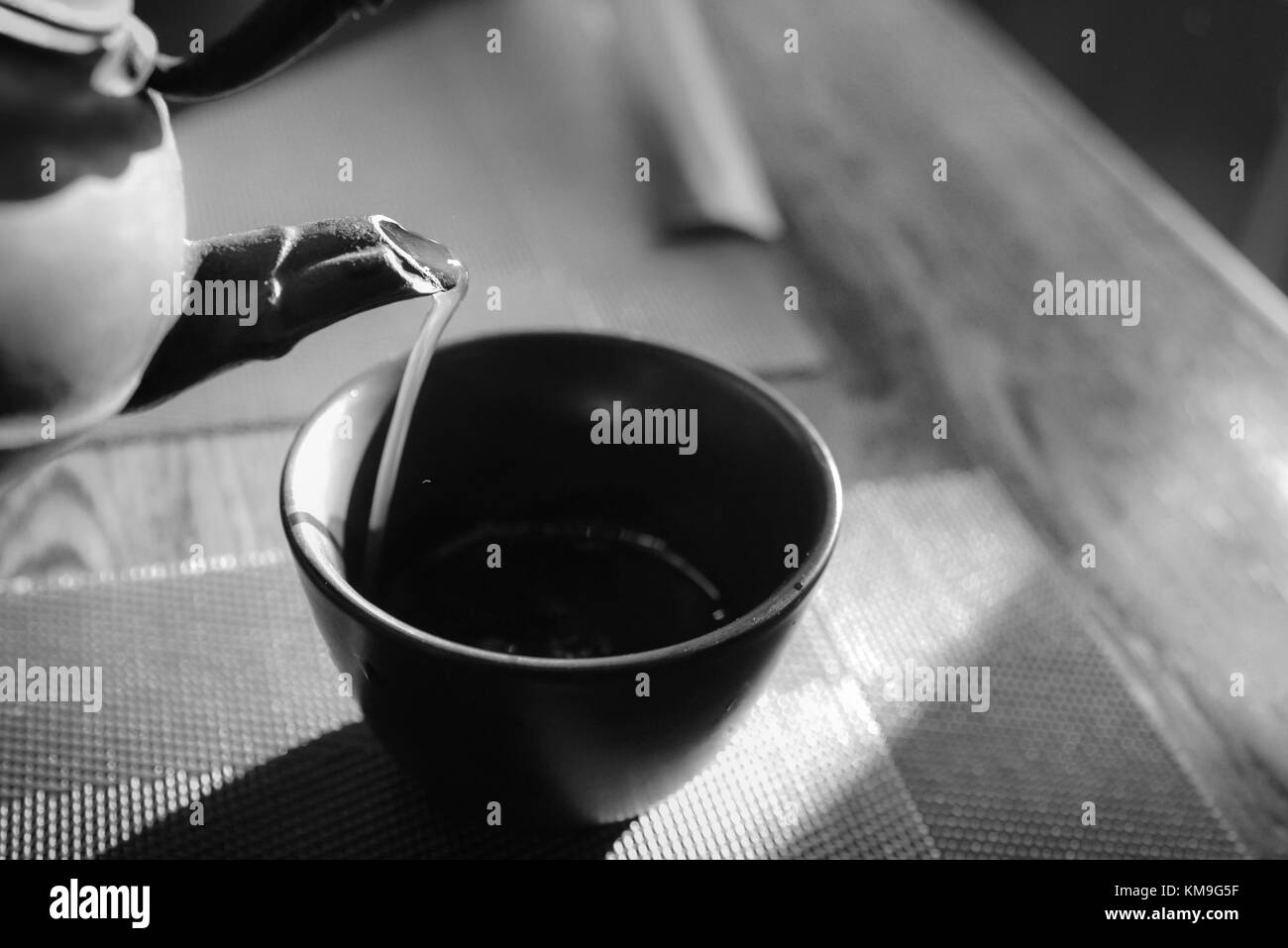 Close up pouring a hot Japanese green tea kettle on an oriental style