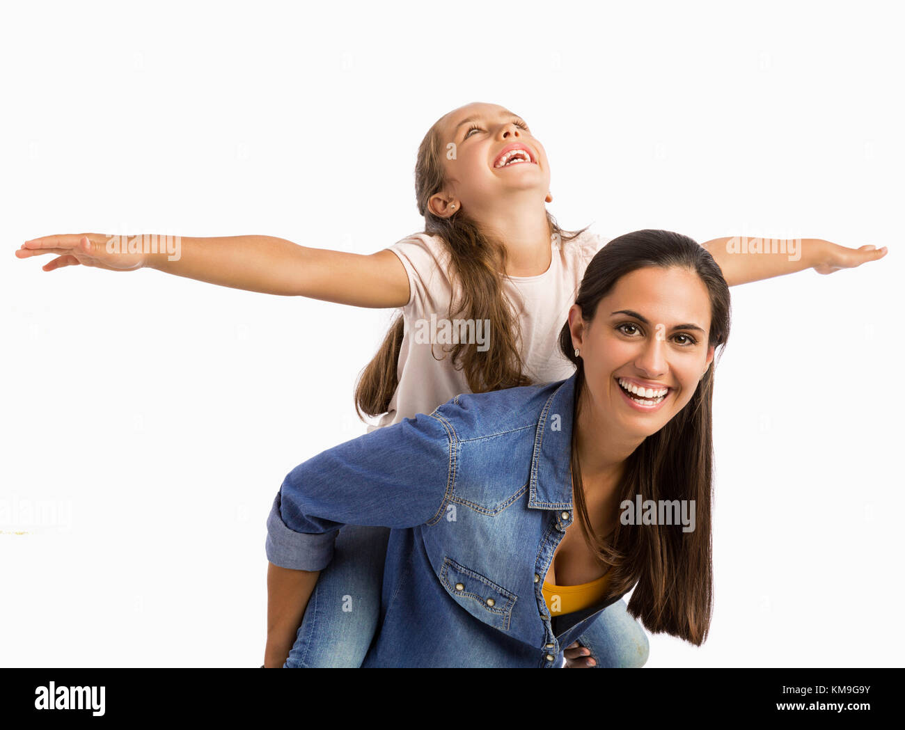 Mother giving her Daughter a ride On her back while playing Stock Photo