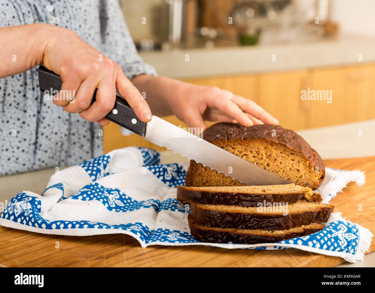 Woman cutting slices of gluten-free bread Stock Photo