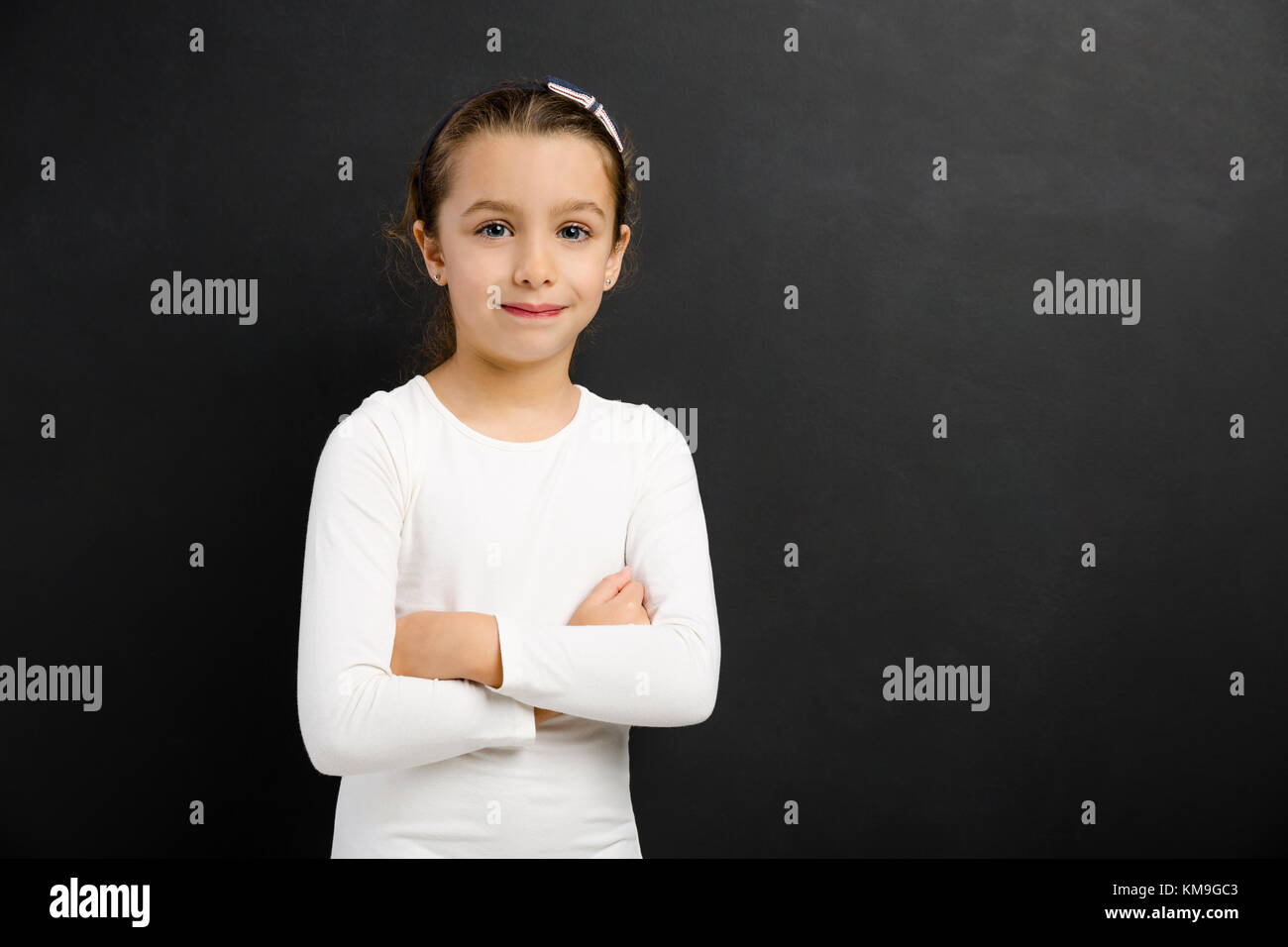 Smart little girl smiling in front of a blackboard Stock Photo - Alamy