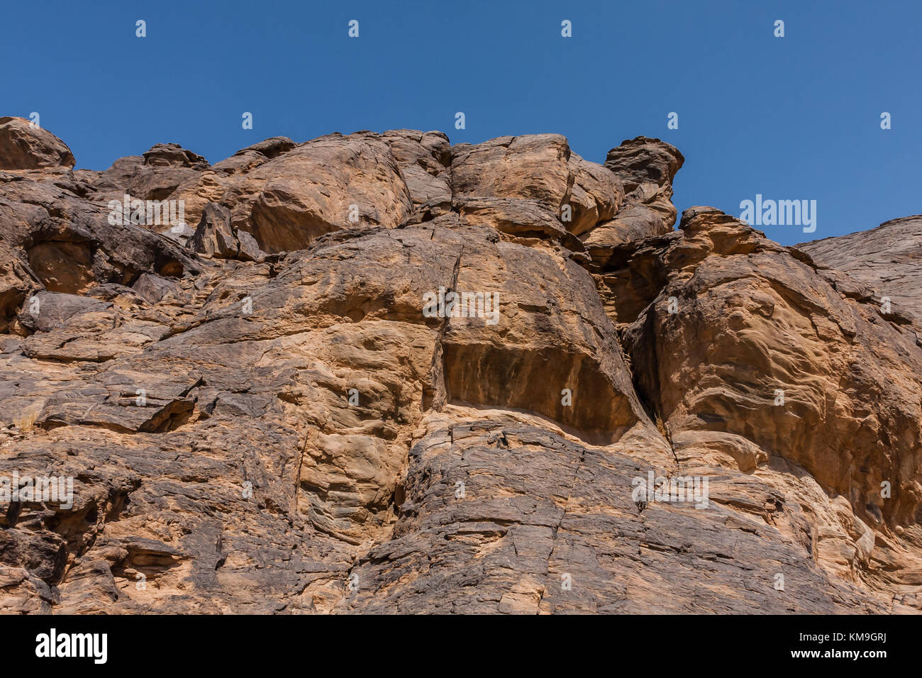 A rock cliff with the pre-islamic inscriptions at the north entrance of ...