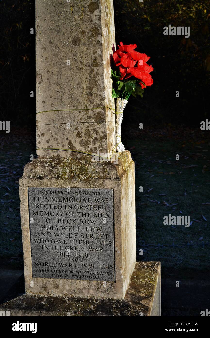 Close up of village war memorial with red flowers tied to it Stock ...