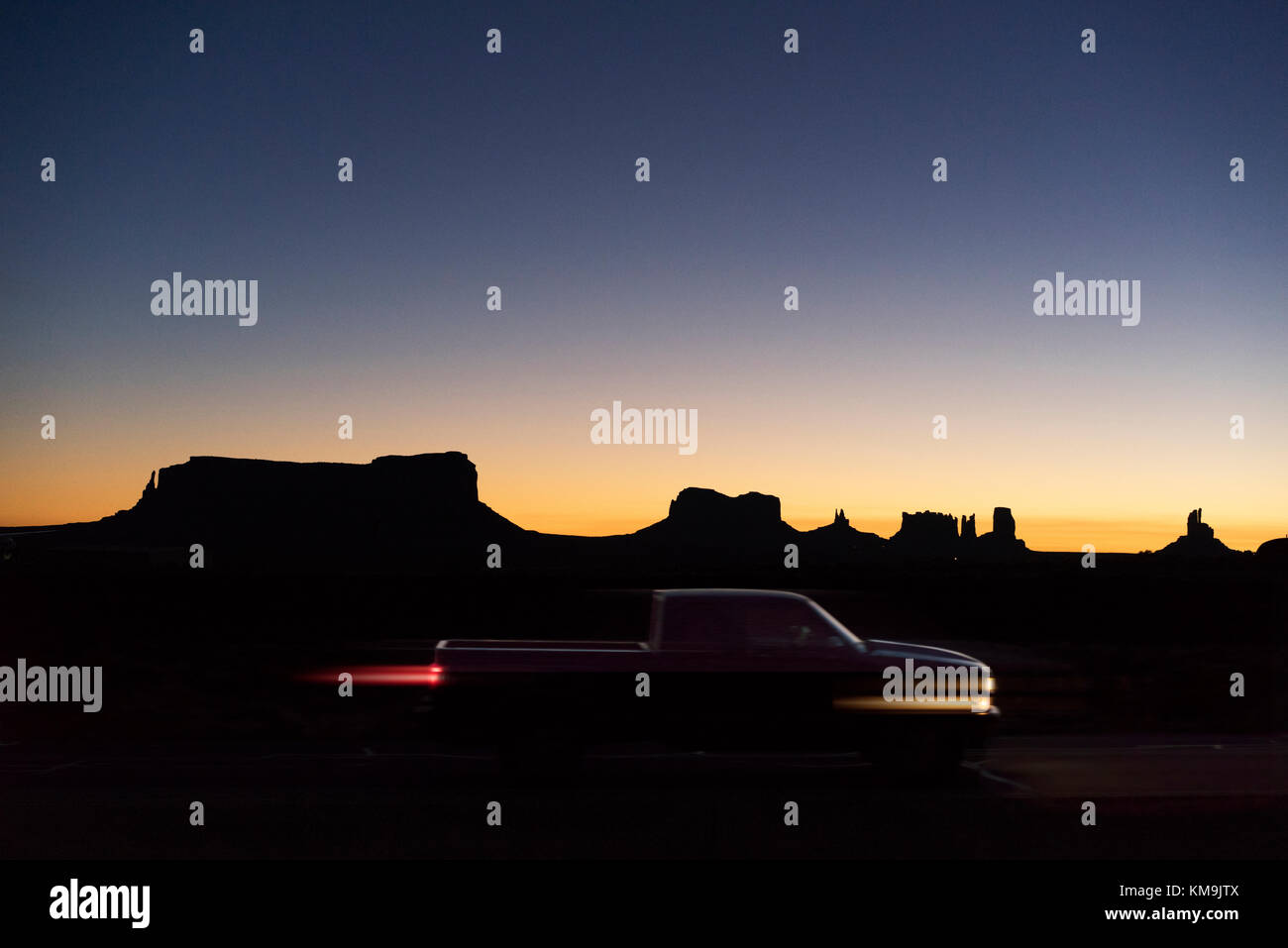 Local Navajo people start the day with the wonderful sunrise and the lights of the mobile settlements in the surrounding desert Stock Photo