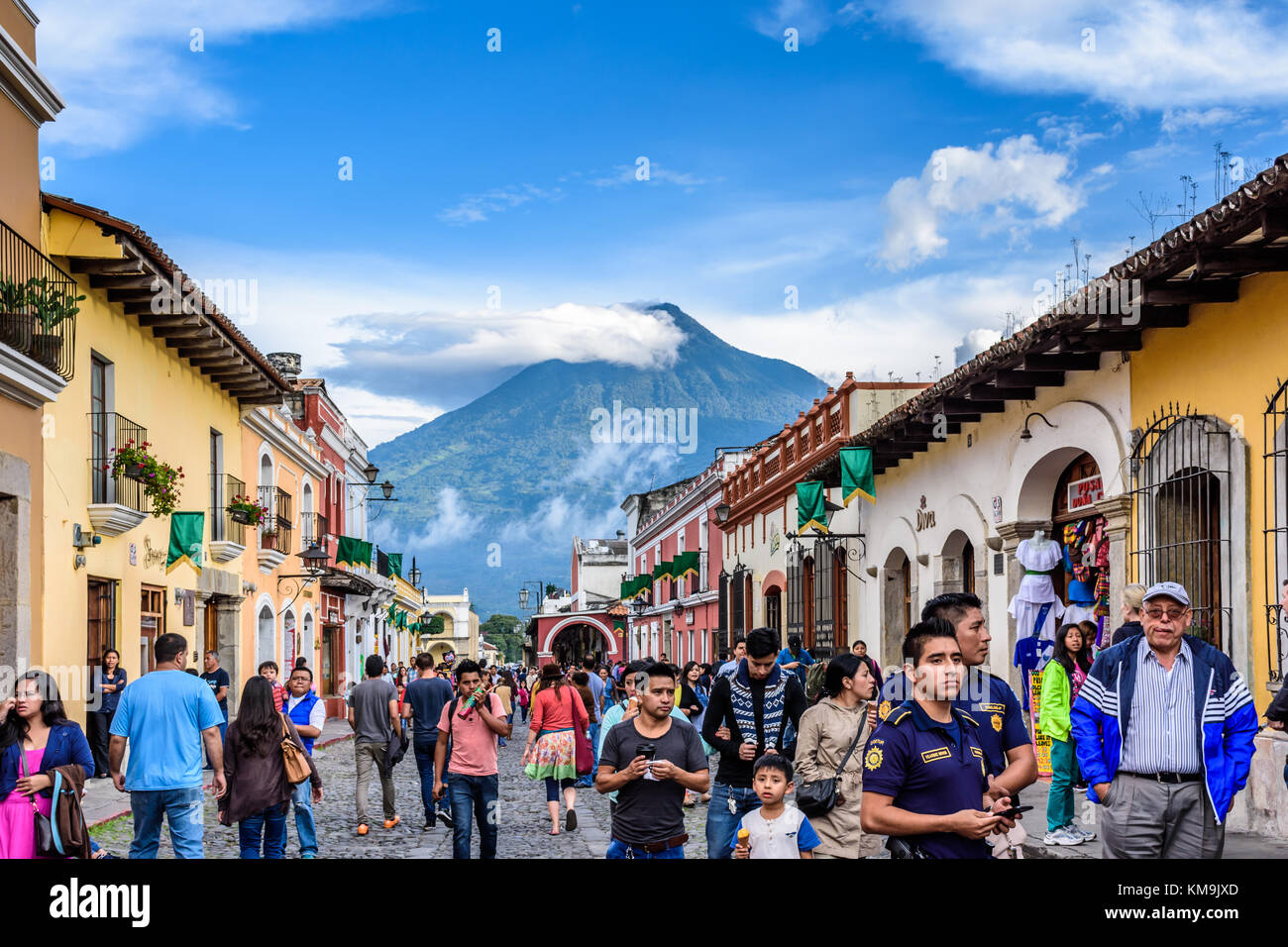 Antigua, Guatemala - July 24, 2016: Tourists walk near central park with view of Agua volcano in UNESCO World Heritage Site Stock Photo