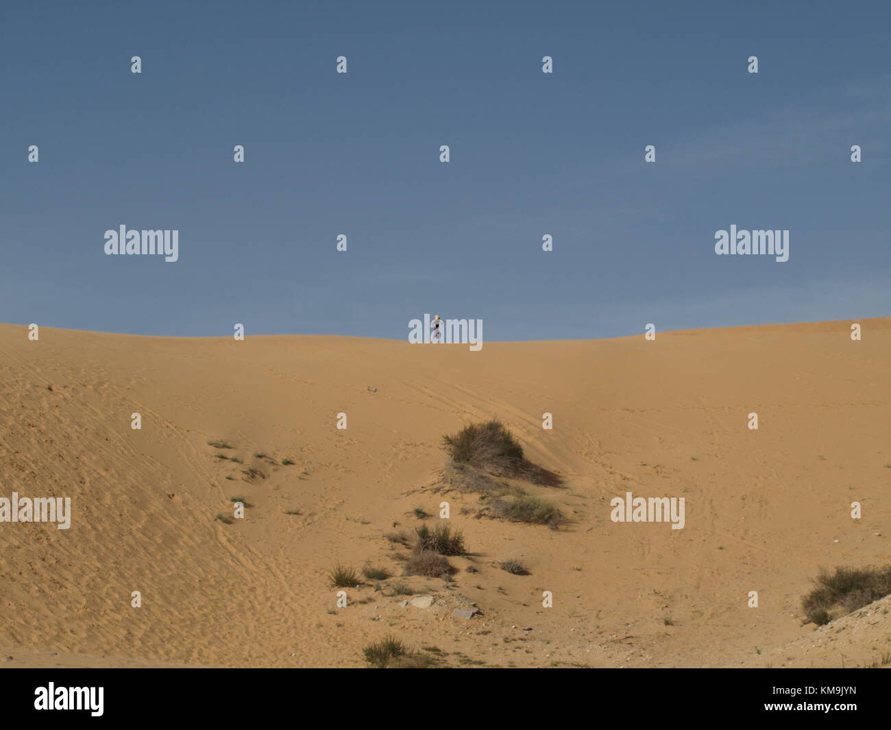 girl standing on a sand dune with the sky background Stock Photo - Alamy