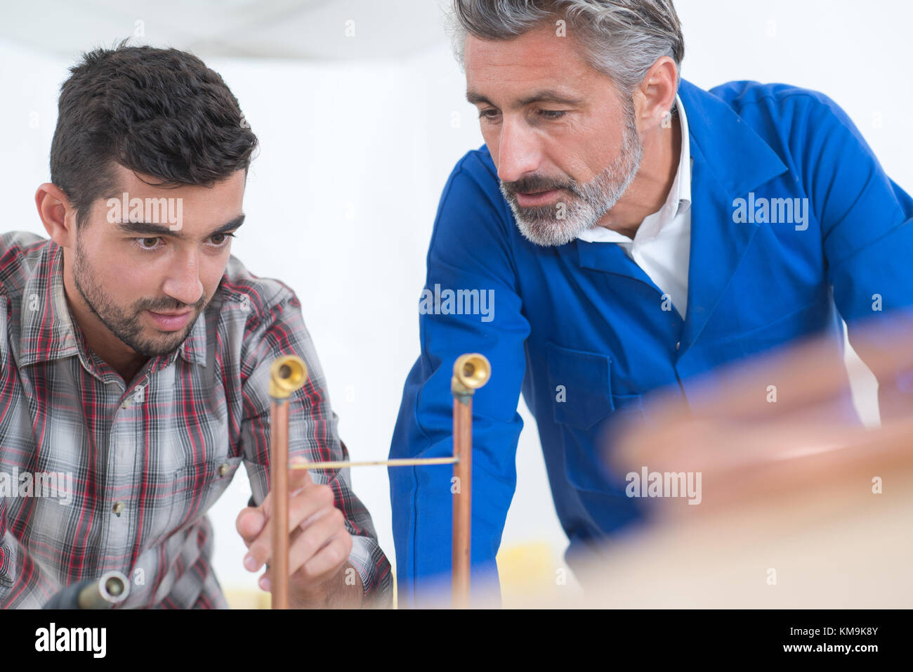 teacher encouraging apprentice using machinery Stock Photo - Alamy