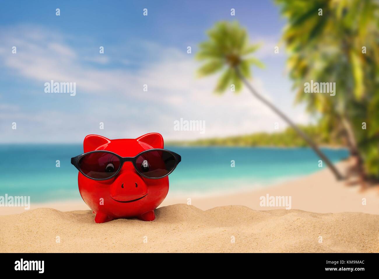 Red piggy bank with sunglasses with a tropical beach in the background ...
