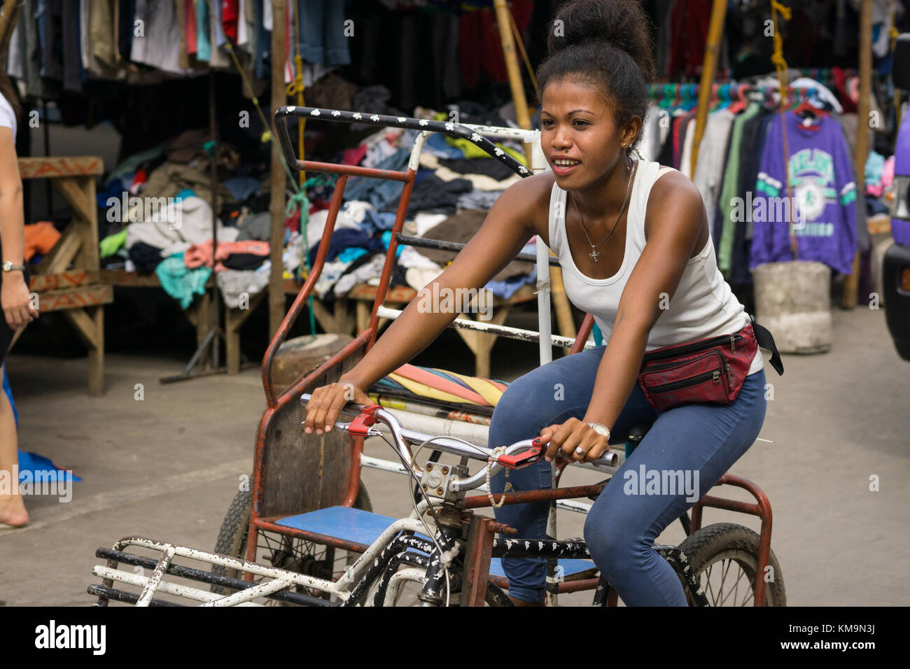 Young Filipino girl Pedaling a Trisikad through the Carbon Market,Cebu City,Philippines Stock Photo