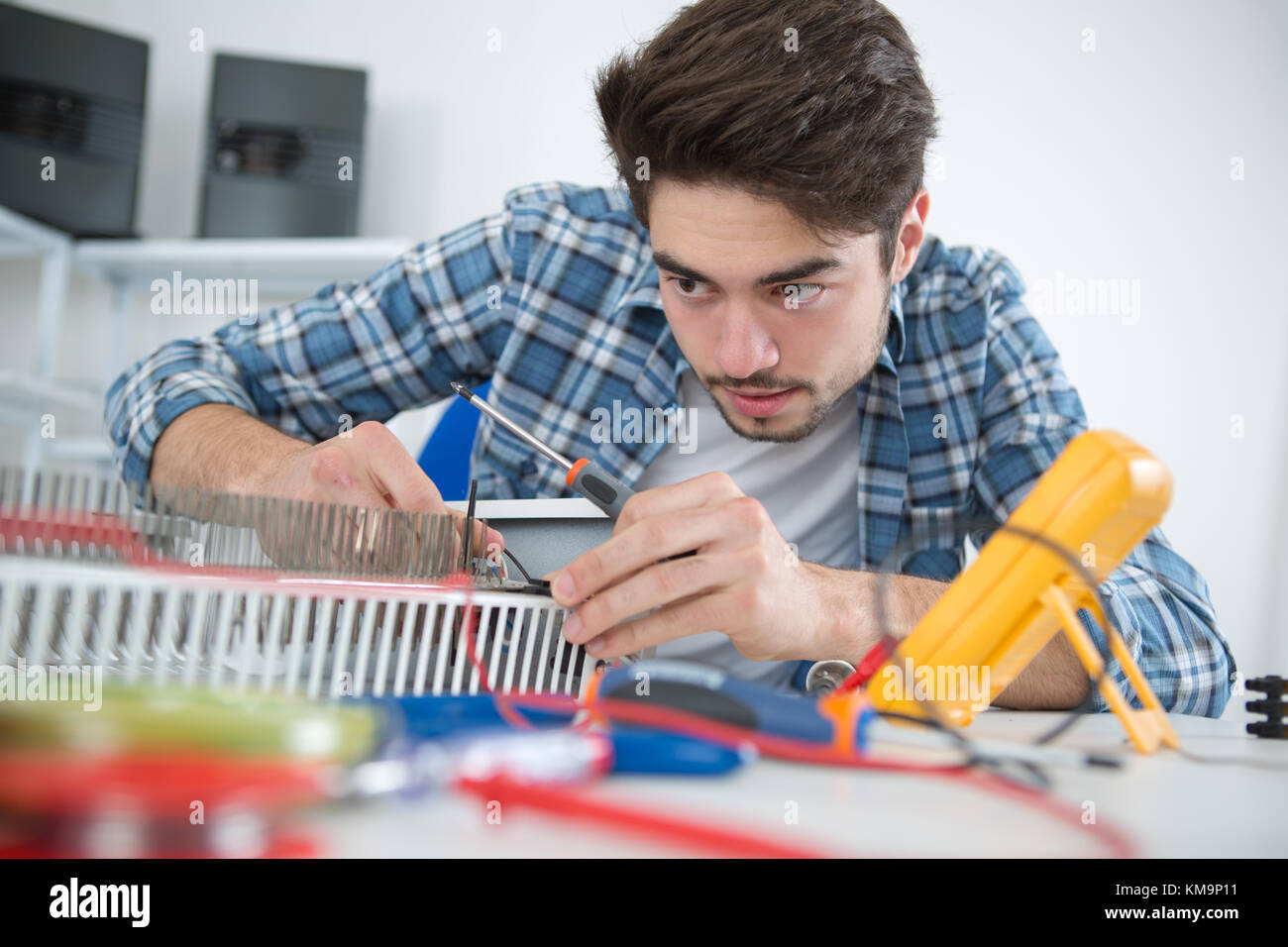young man repairing radiator Stock Photo - Alamy