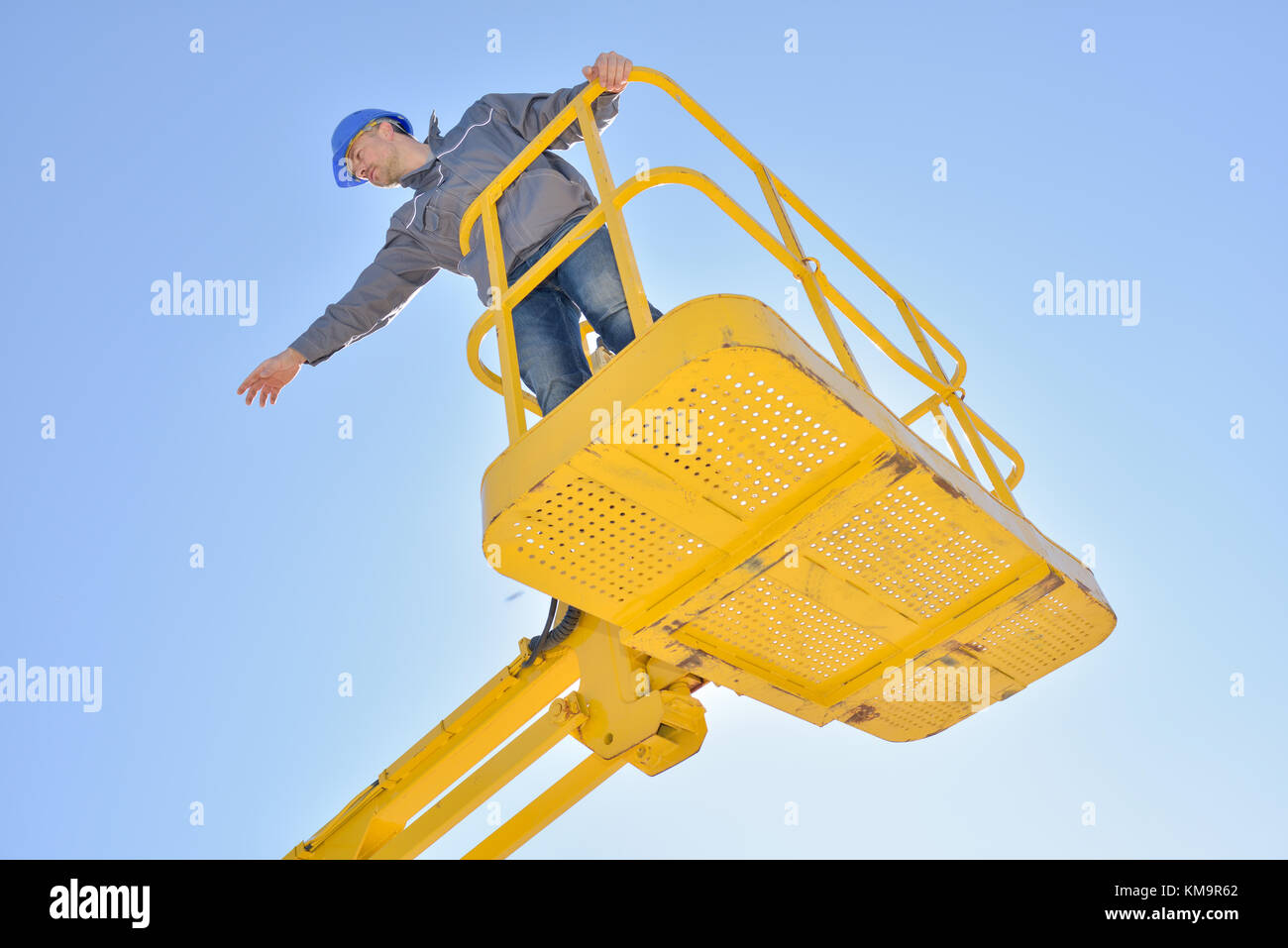 worker man giving directions from a yellow crane Stock Photo