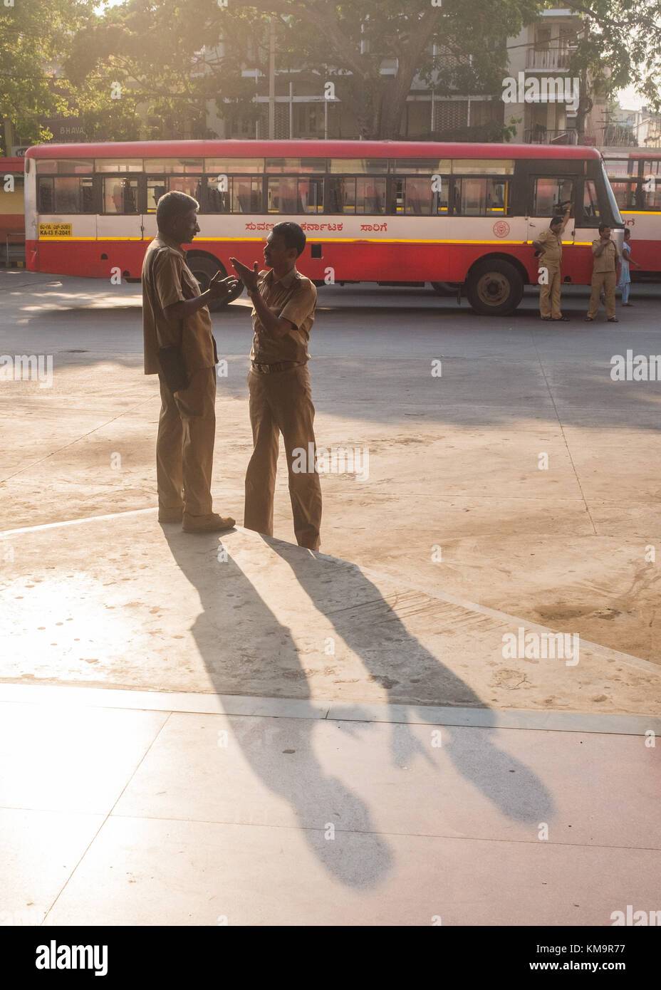 Bus conductor talking with his colleague at bus station in Mysore, Mysuru, Karnataka, India. Stock Photo
