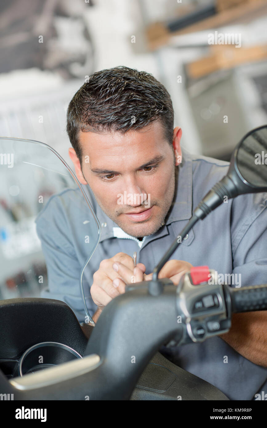 Mechanic working  on scooter Stock Photo
