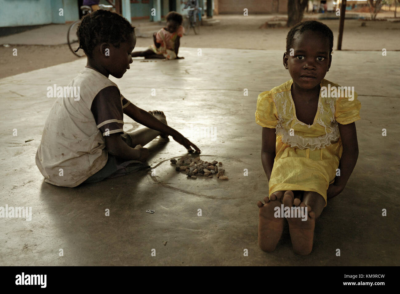 Two kids playing a game with stones in Kawaza village, Eastern Province, Zambia Stock Photo