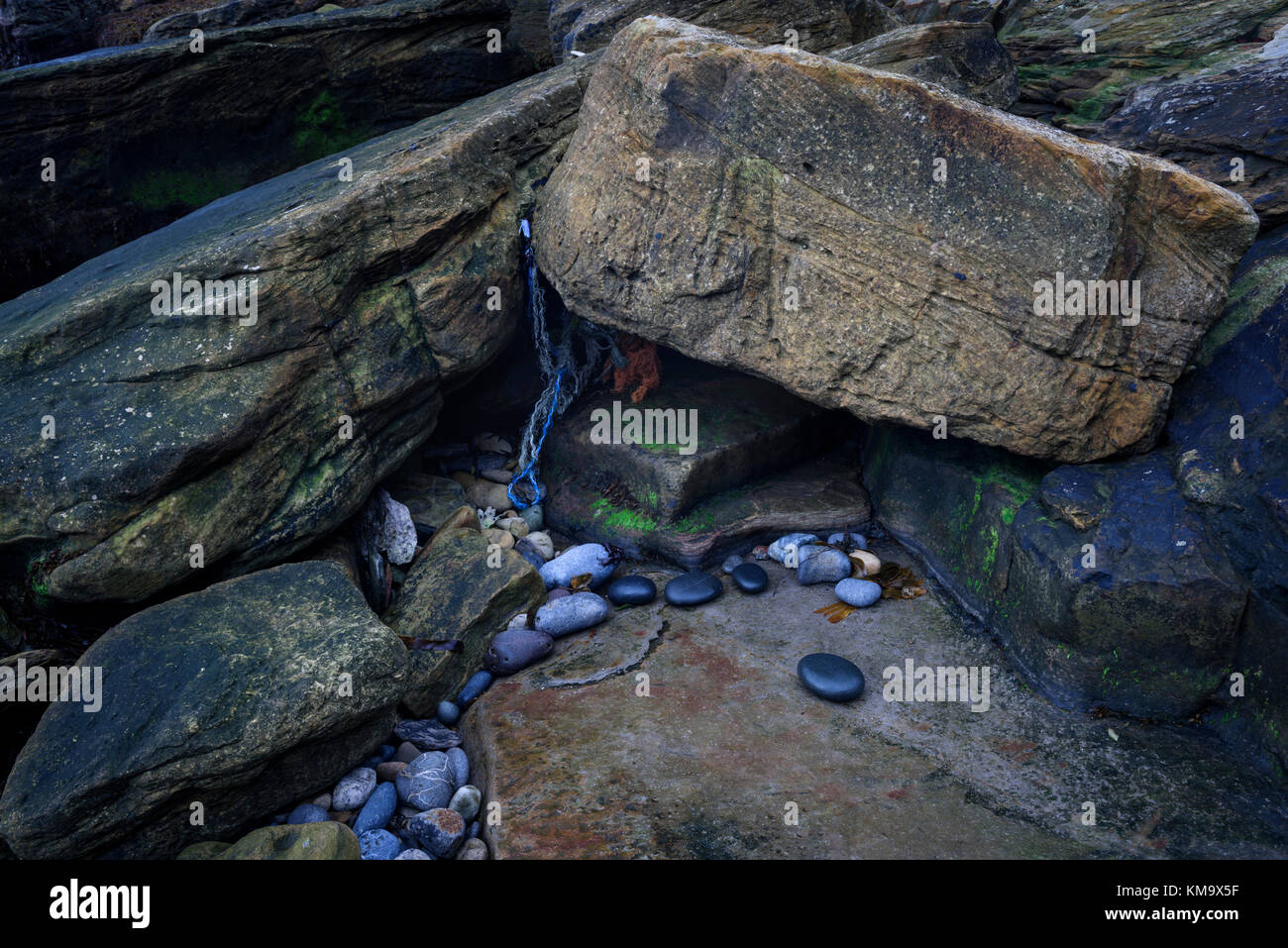 Marine debris washed ashore among coastal rocks on the Northumberland ...