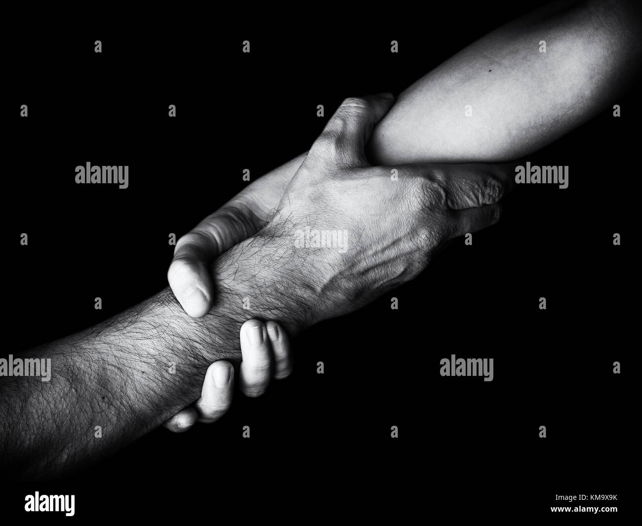 Woman saving rescuing and helping man by holding or griping the forearm Female hand and arm pulling up male. Concept of rescue love friendship support Stock Photo