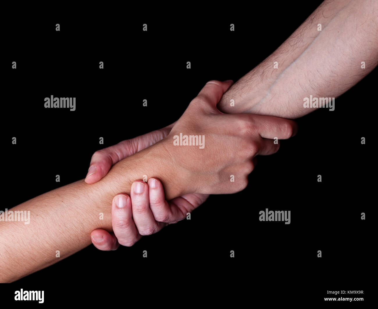 Man saving, rescuing and helping woman by holding or griping the forearm. Male hand and arm pulling up female. Concept of rescue, love, friendship, su Stock Photo