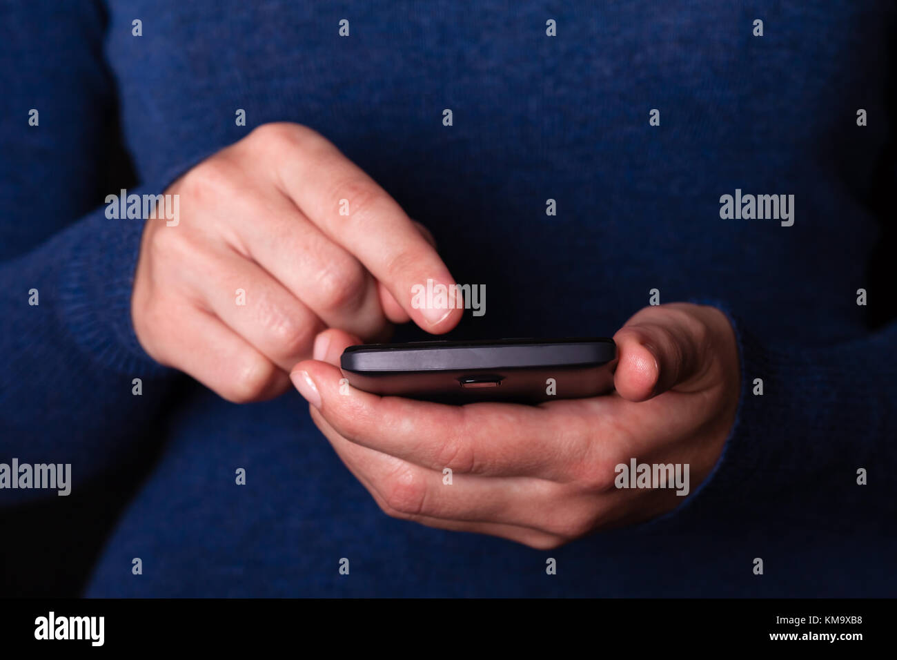 Woman holding and touching screen or display with finger of a mobile phone, cell phone or smartphone. Female businesswoman typing a message or browsin Stock Photo