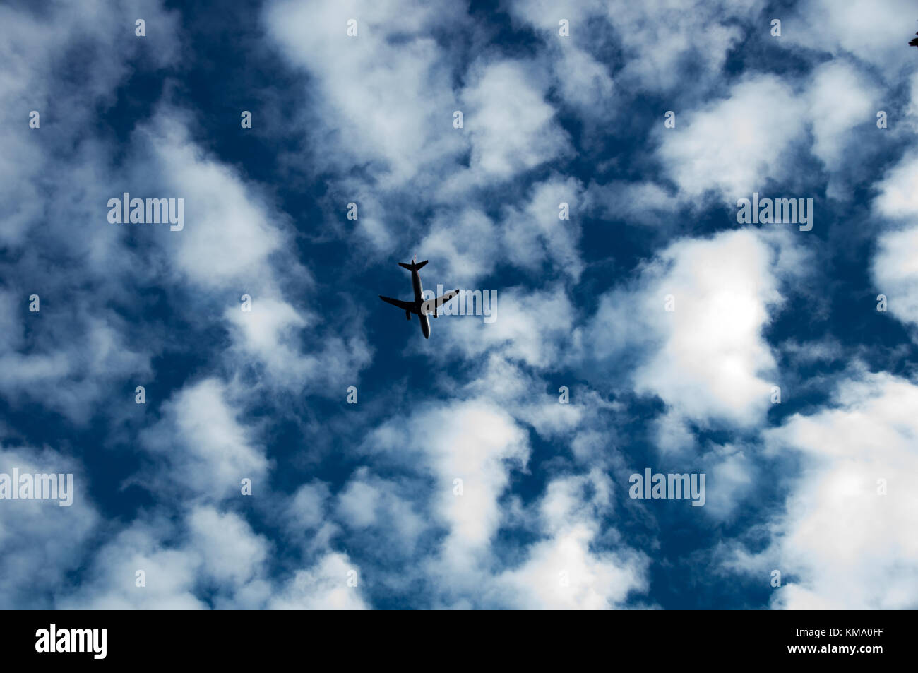 Plane flying in the cloudy sky Stock Photo