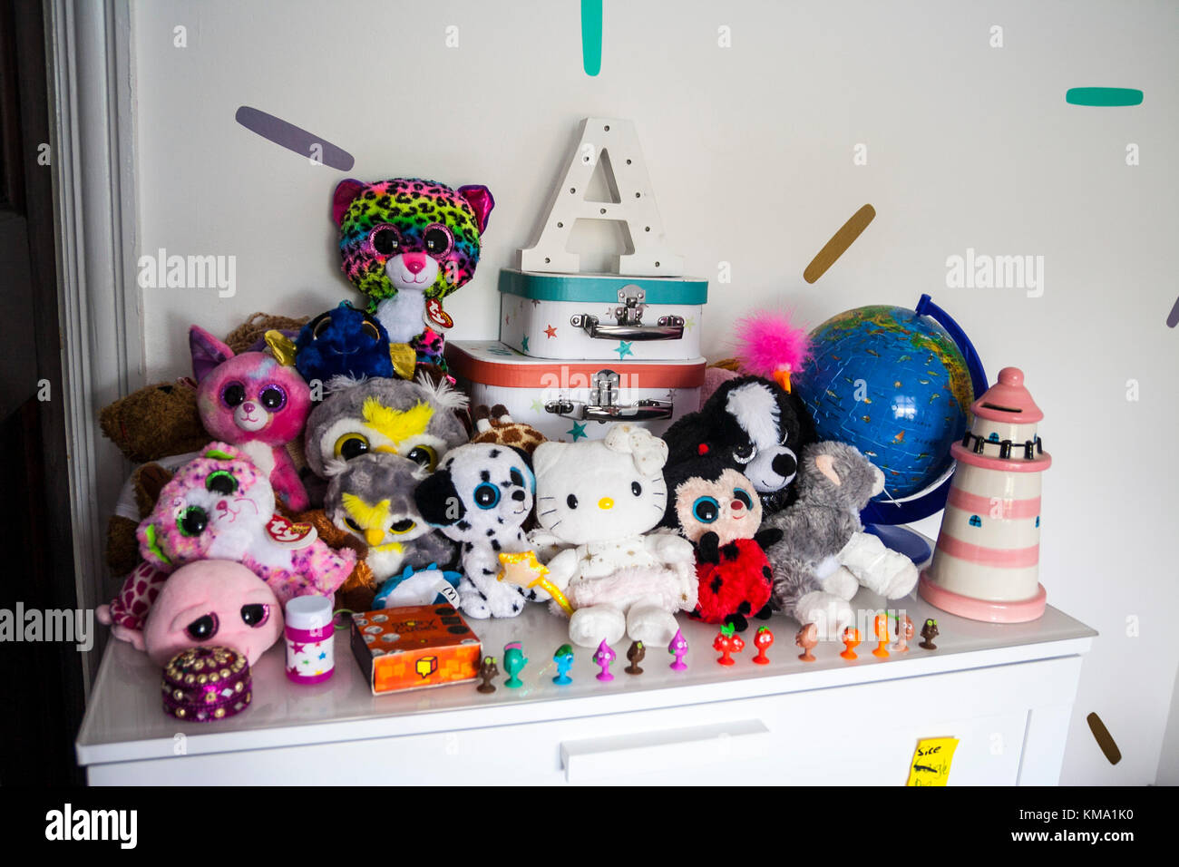 Toys on a shelf in a child's bedroom, TY beanie boo, lighthouse money box, globe, games Stock Photo