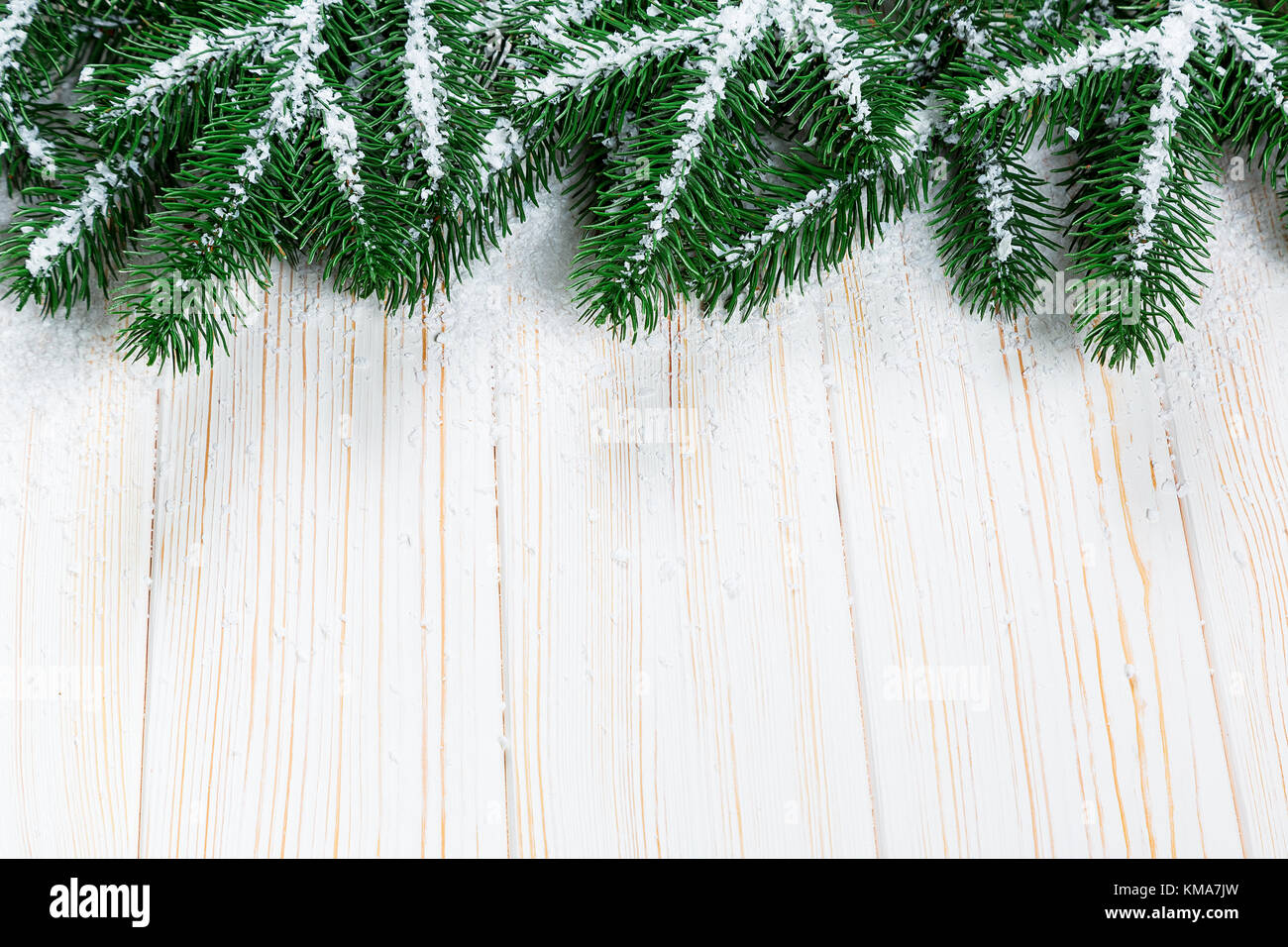 Christmas fir tree with snow on white wooden background. Free space ...
