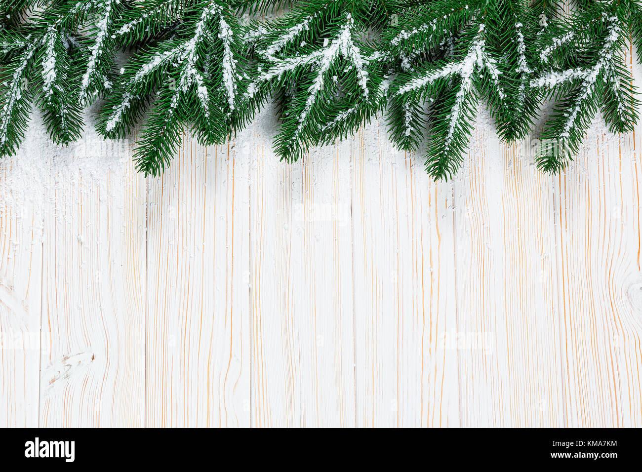 Christmas fir tree with snow on white wooden background. Free space ...
