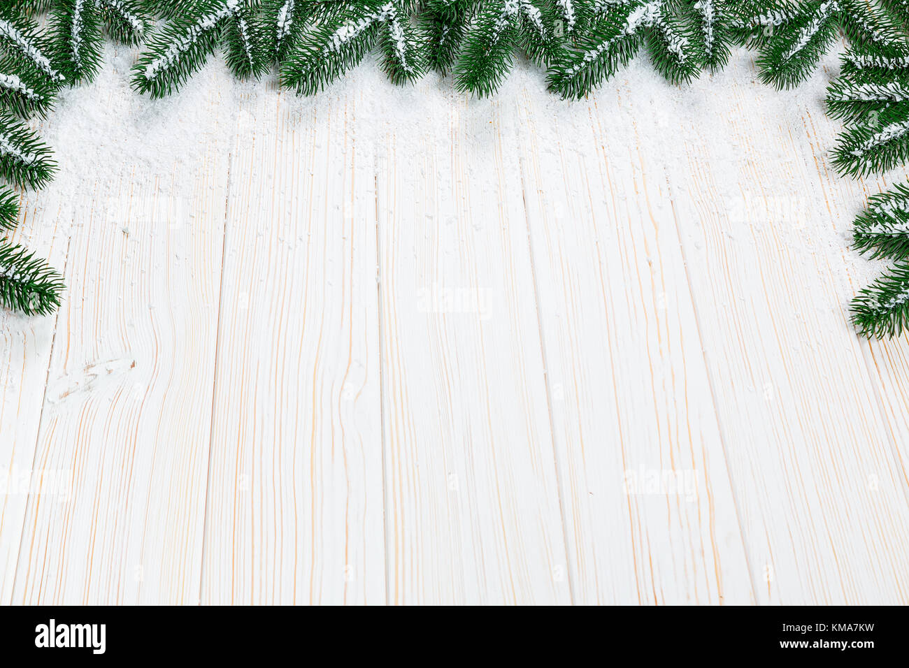 Christmas fir tree with snow on white wooden background. Free space ...