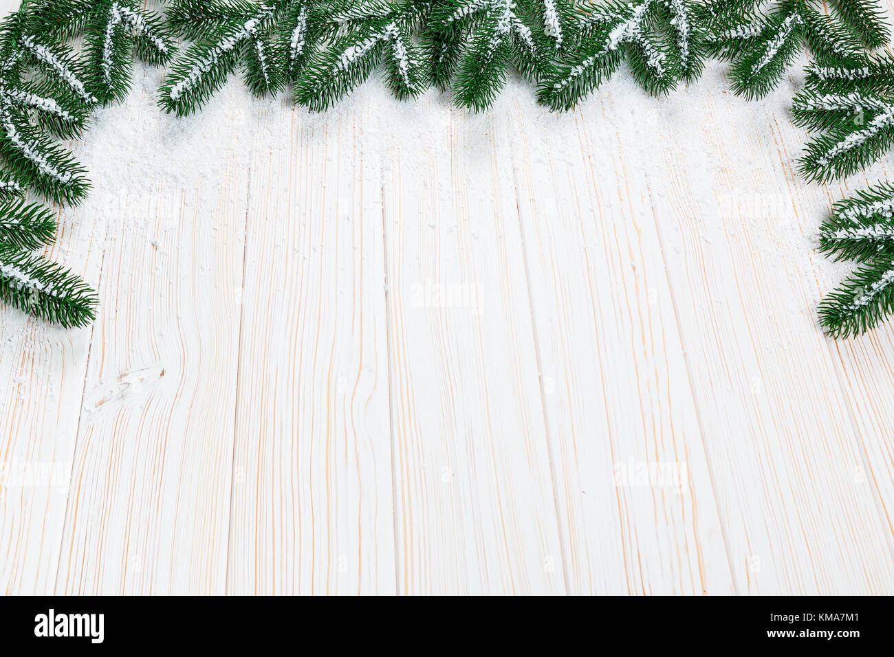 Christmas fir tree with snow on white wooden background. Free space ...