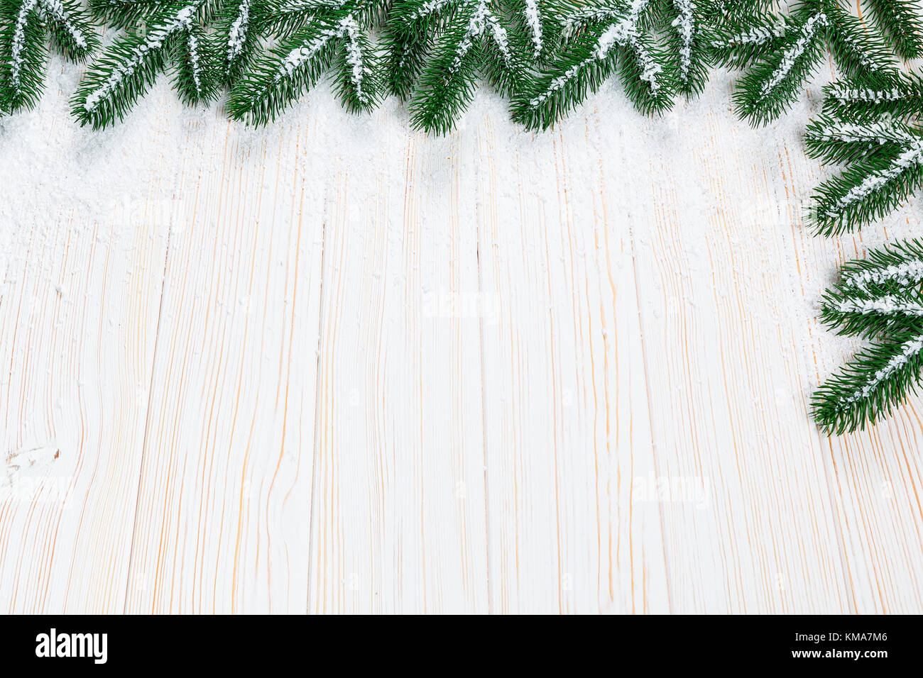 Christmas fir tree with snow on white wooden background. Free space ...