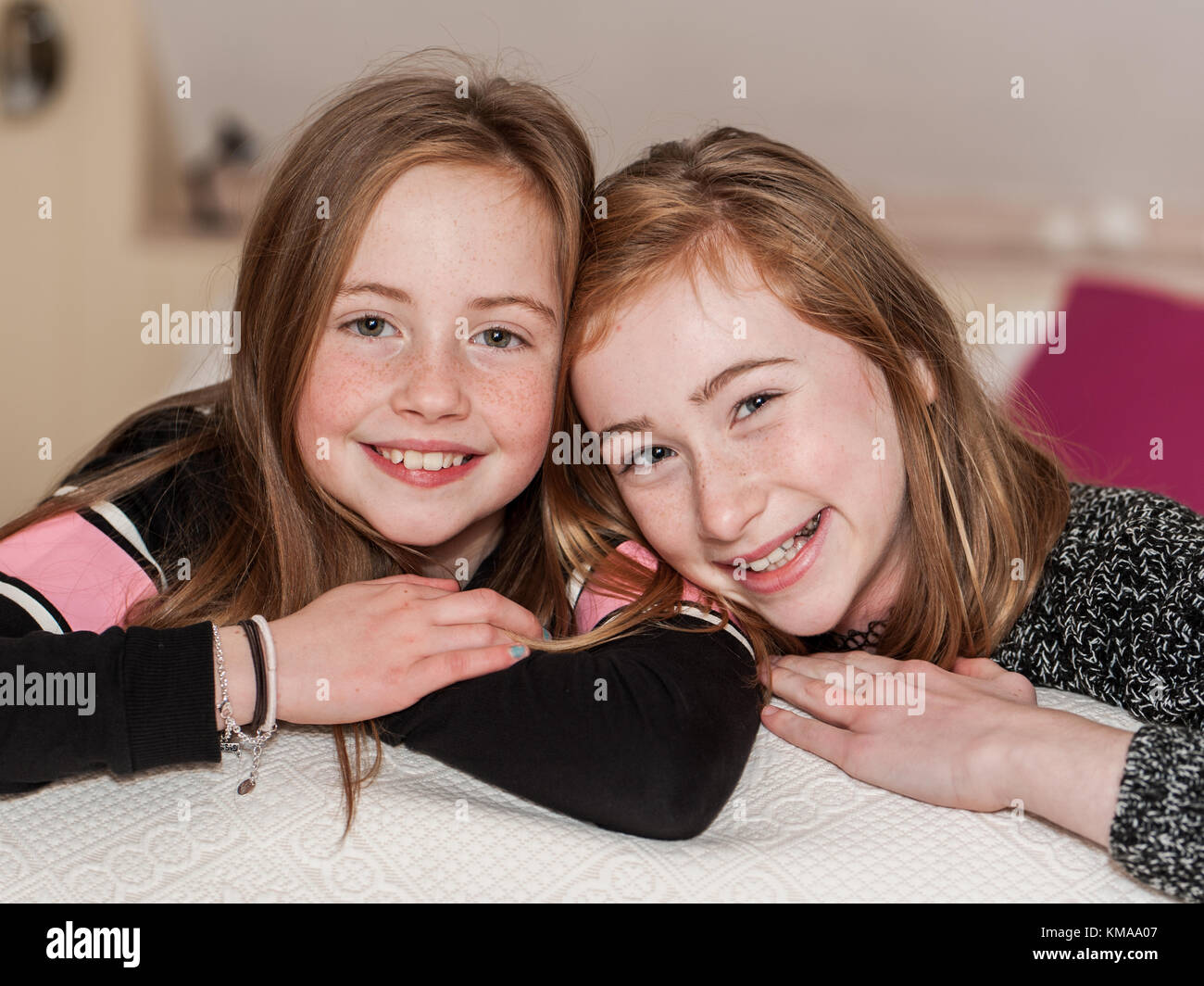 Two smiling young girls posing for the camera as a best friends forever concept. Stock Photo