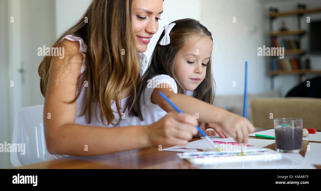 Little girl painting with her mother at home Stock Photo - Alamy