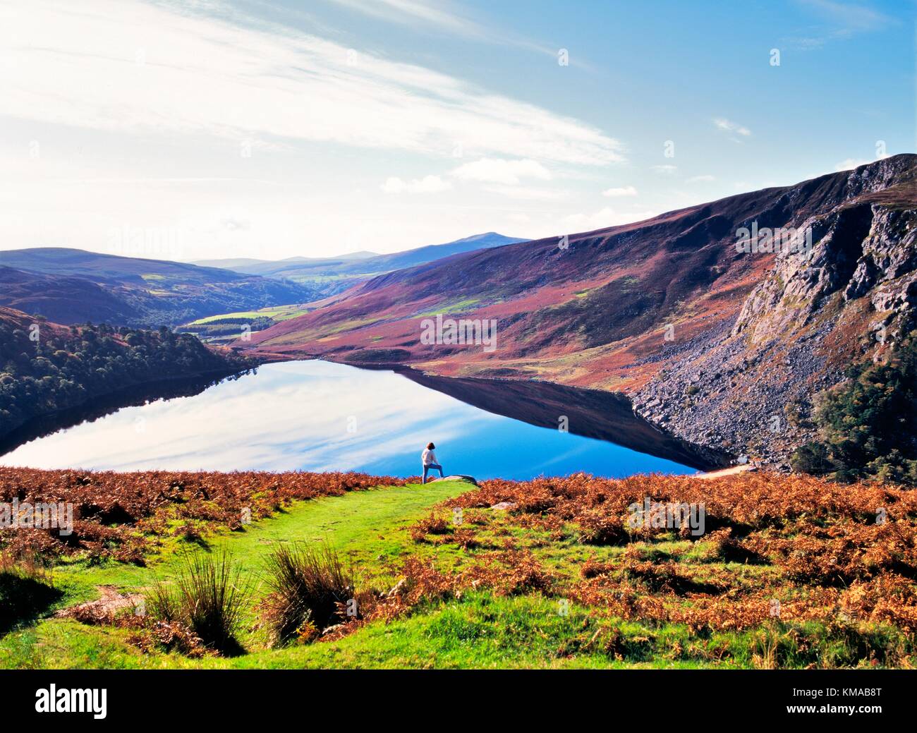Young woman in Aran sweater looking south over Lough Tay in the Wicklow Mountains south of Dublin, Ireland. Stock Photo