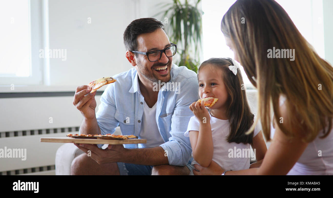 Happy family sharing pizza together at home Stock Photo