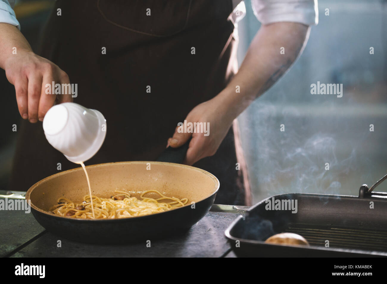 Chef is pouring the sauce into spaghetti Stock Photo Alamy