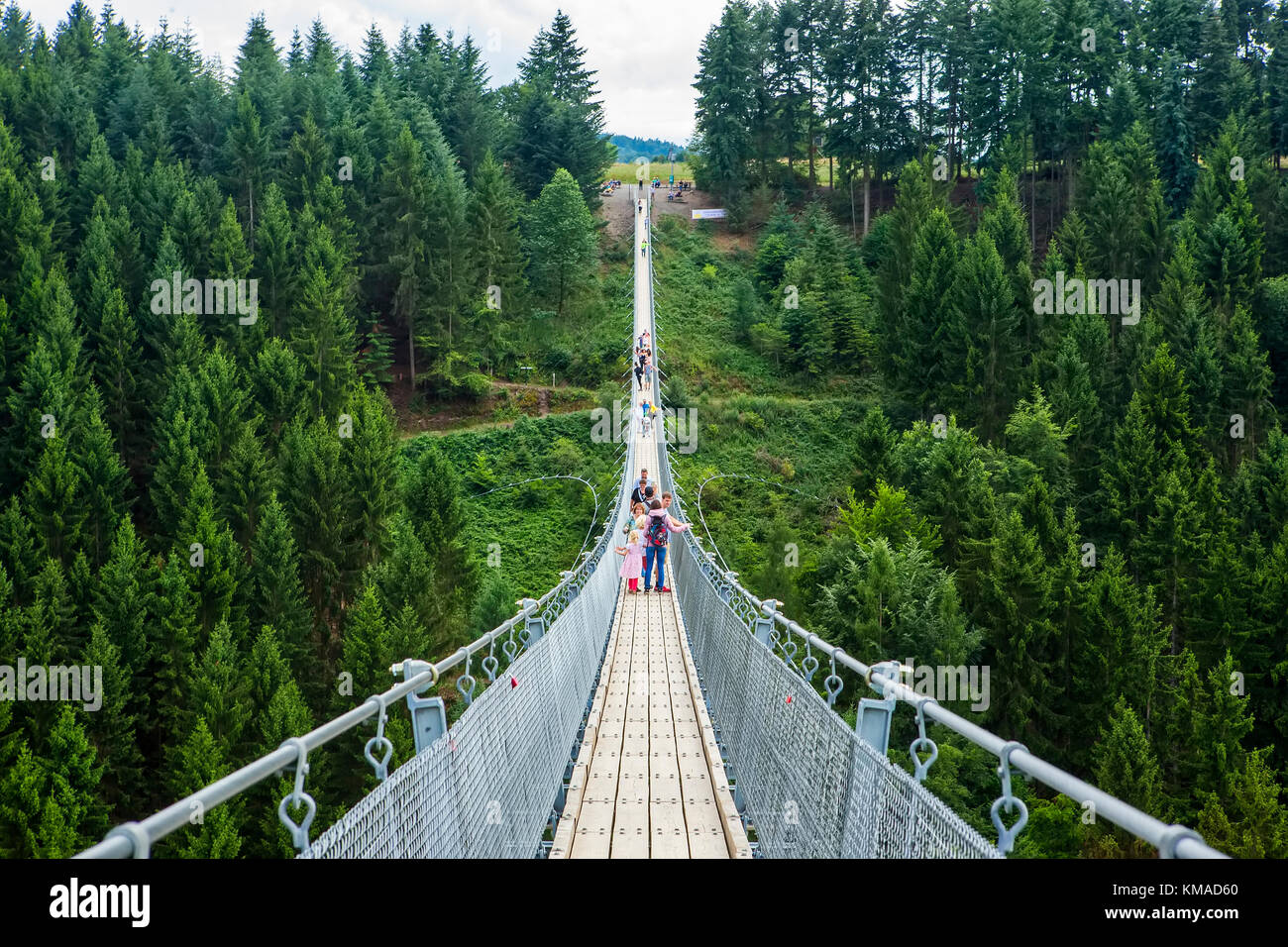 Geierlay, Morsdorf, Germany - July 11, 2017: Holidaymakers cross Germany's longest rope suspension bridge 300 feet above a canyon floor Geierley. It i Stock Photo