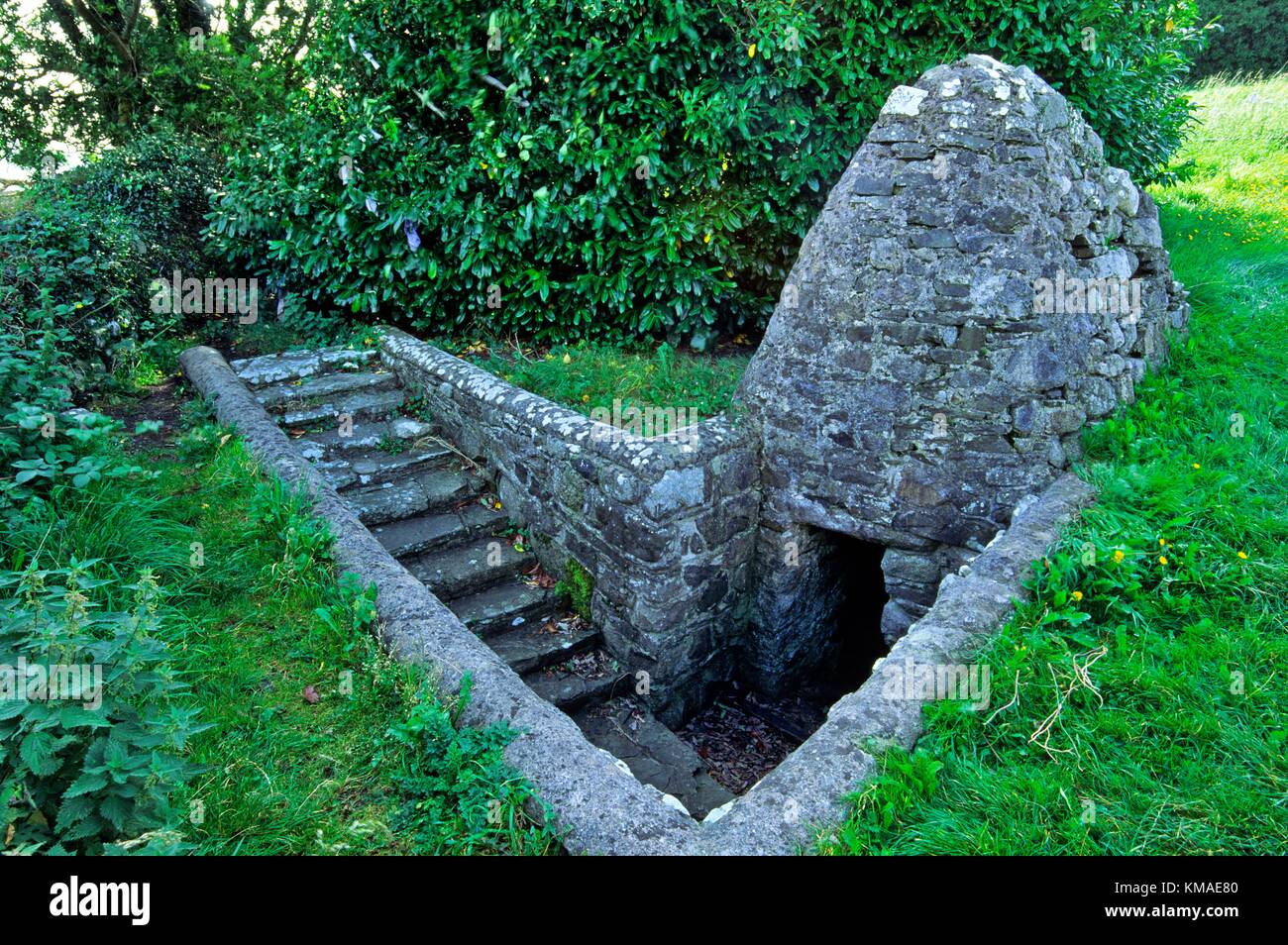 St. Brigid's Well with clootie tree behind in the ancient Celtic Christian church site on Faughart Hill, County Louth, Ireland. Stock Photo