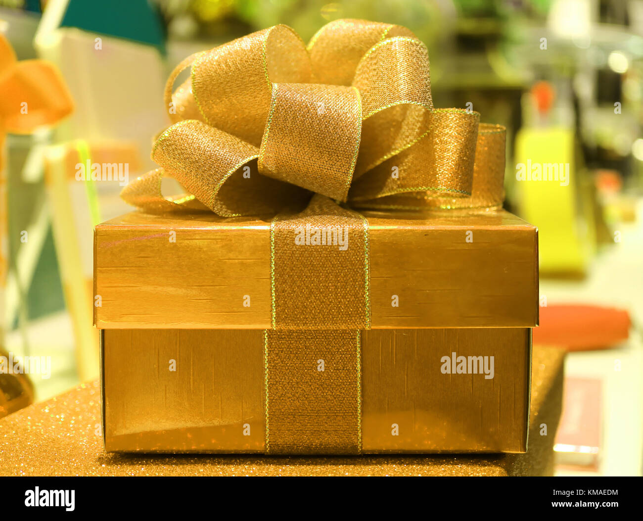 Front View of a Square Shiny Gold Gift Box with Glitter Gold Ribbon Bow ...
