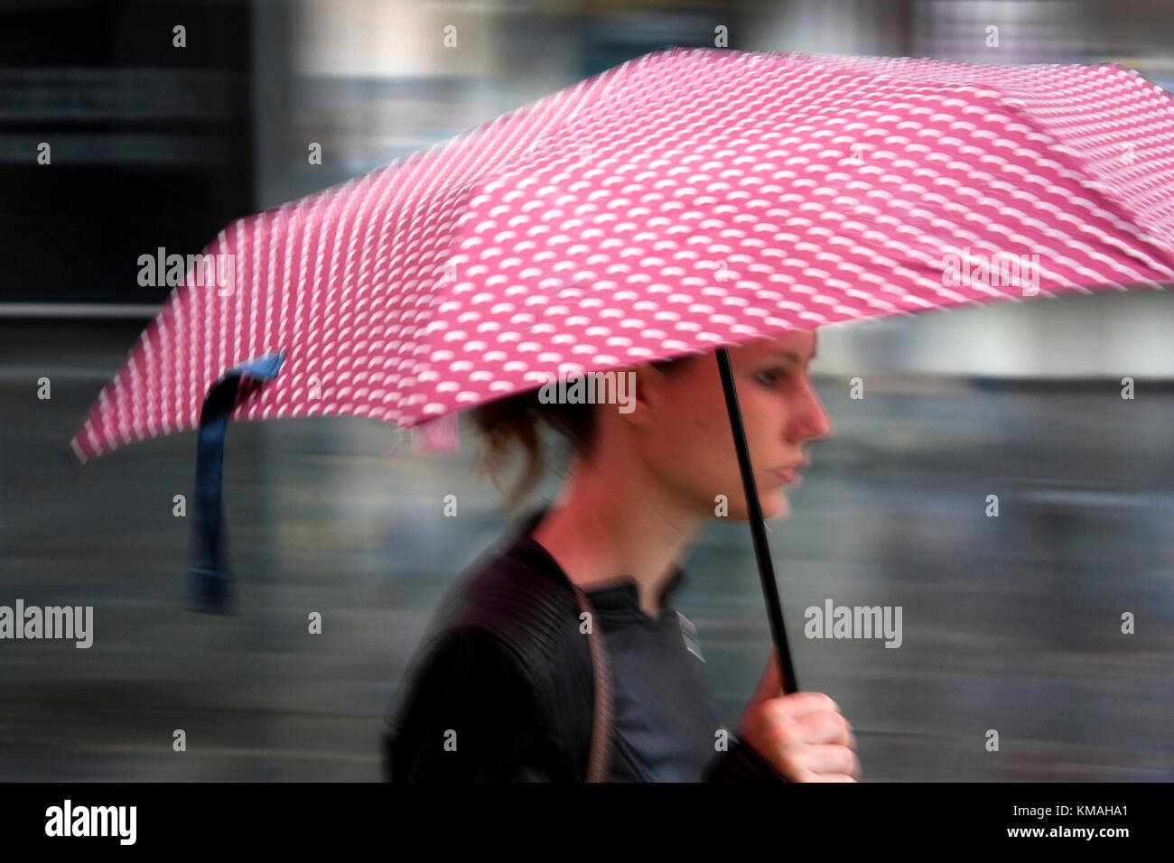 Belgrade, Serbia- September 25, 2017: Blurry young woman walking under red umbrella Stock Photo