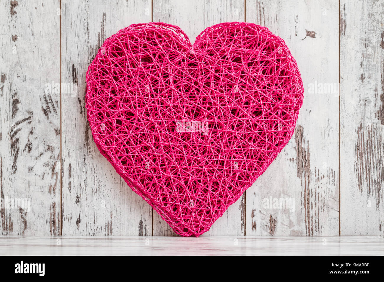 Heart shaped american style pink table mat on white wooden  background Stock Photo