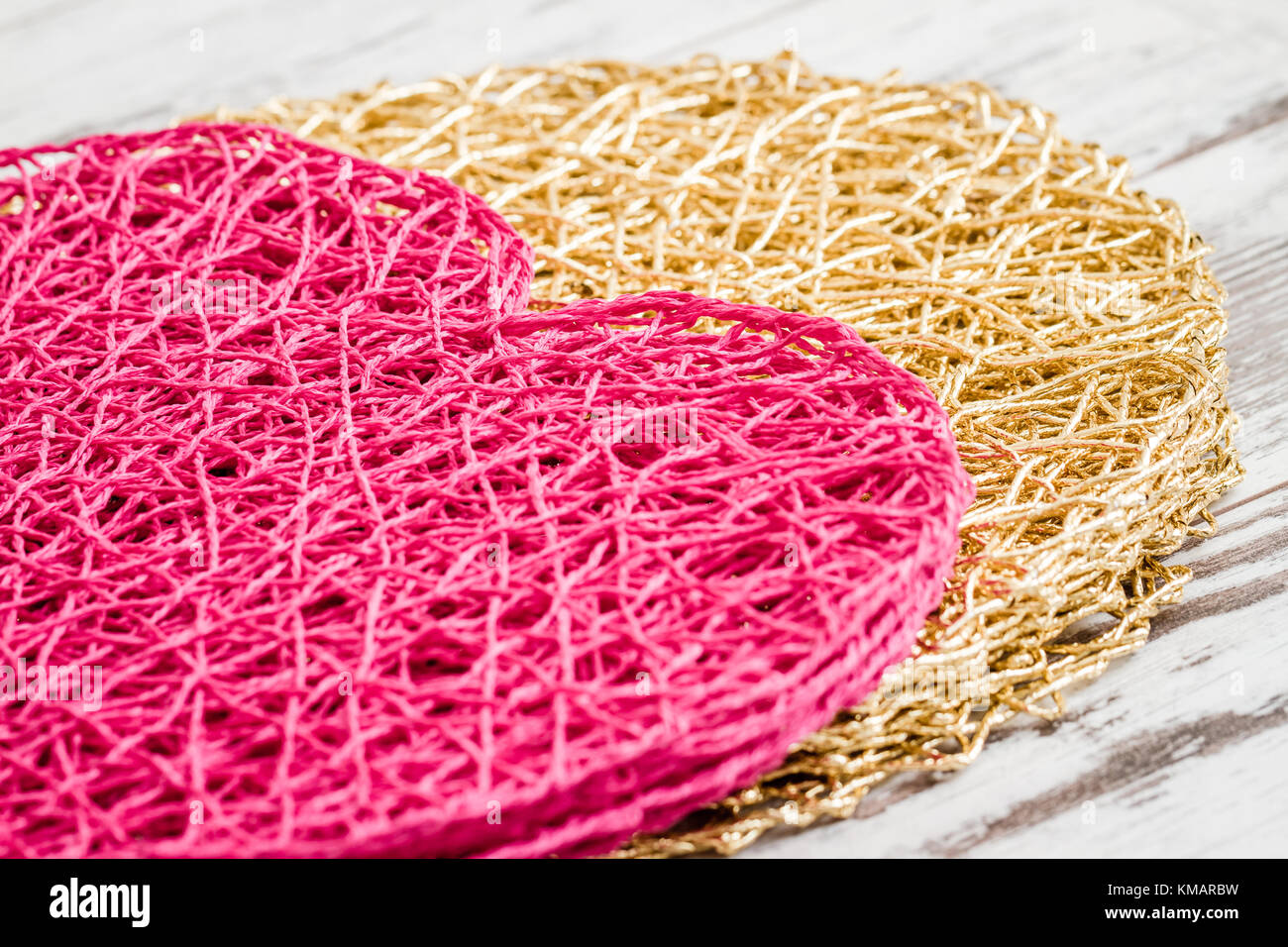 Heart shaped american style pink table mat on white wooden  background Stock Photo