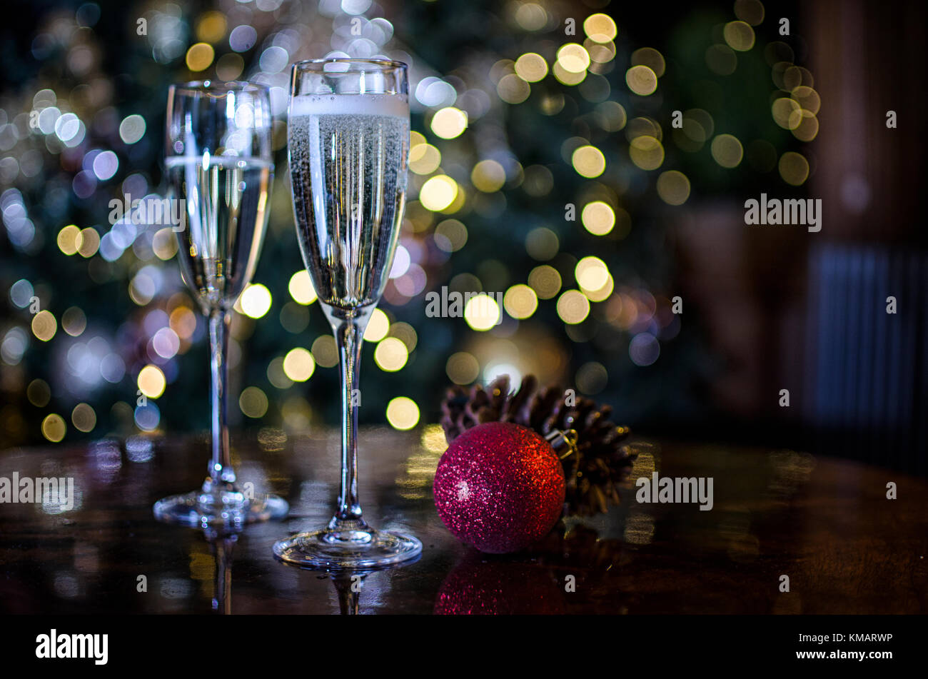 Two Champagne Glasses surrounded by Christmas Decorations Stock Photo